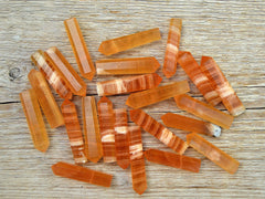 Several small honey calcite crystal points 55mm on wood table