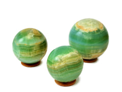 Thre large green pistachio calcite spheres 60mm-100mm on white background