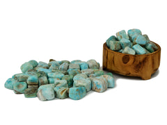 Some blue aragonite tumbled crystals inside  wood bowl and several stones arround