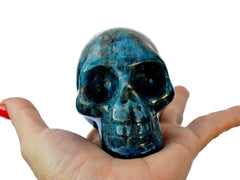 One blue apatite skull carvedstone 75mm on hand with white background