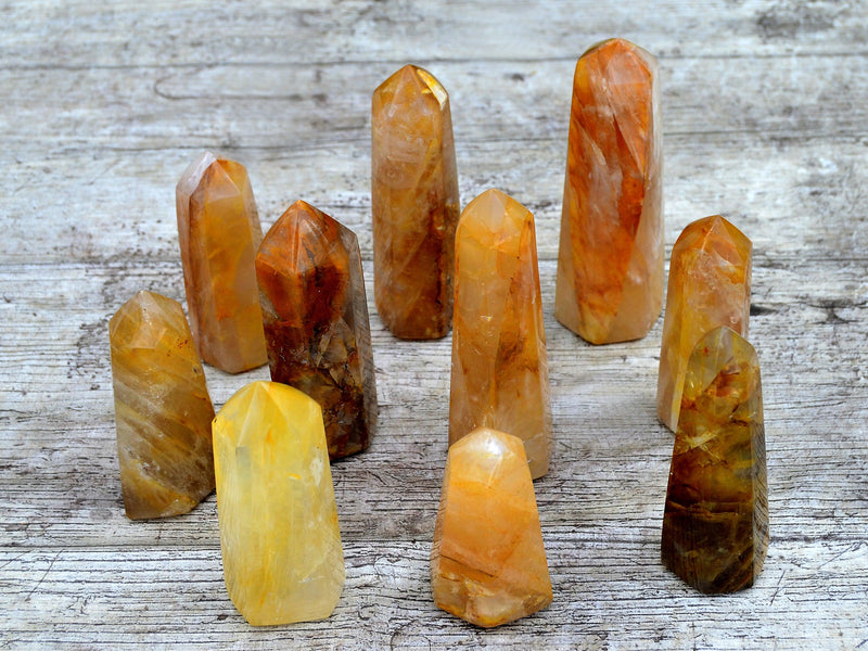 Ten yellow hematoid quartz points on wood table