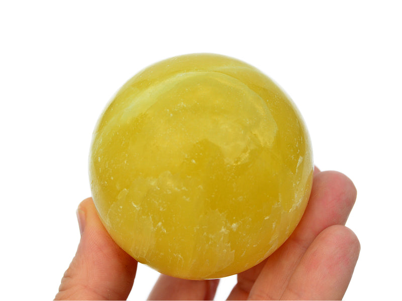 One lemon calcite sphere stone 55mm on hand with white background