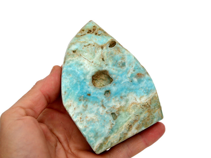 One large blue aragonite free form 90mm on hand with white background