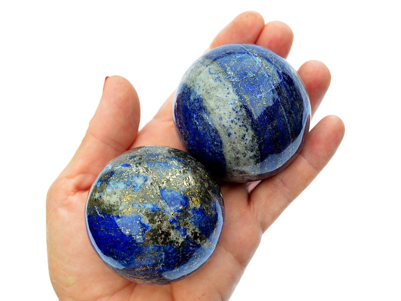 Two blue lapis lazuli sphere stones 55mm-60mm on hand with white background