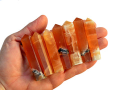 Seven honey calcite small towers 55mm-60mm on hand with white background