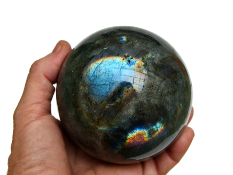 One big labradorite sphere 85mm on hand with white background