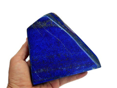 Natural lapis large free form stone 150mm on hand with white background