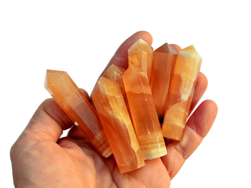 Some small orange calcite faceted points 55mm-60mm on hand