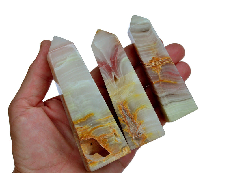 Three pink banded onyx tower crystals 90mm on hand with white background