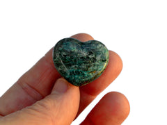 One green chrysocolla crystal hearts 30mm on hand with white background