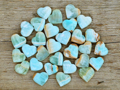 Several blue green caribbean calcite heart shapped crystals 35mm-40mm on wood table