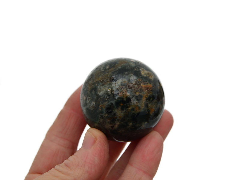 One gree and brown ocean jasper sphere 40mm on hand with white background