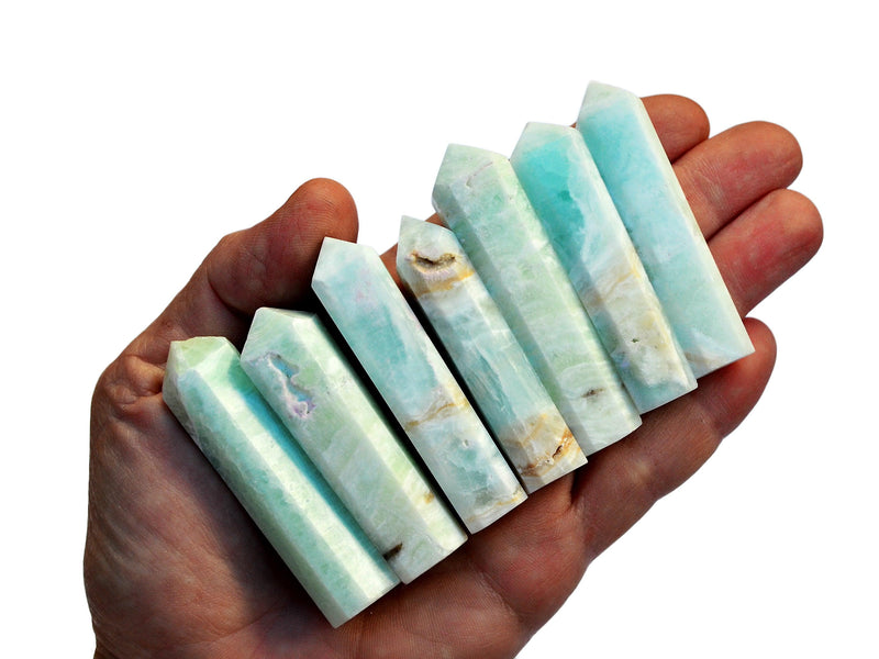 Seven blue caribbean calcite points 55mm-65mm on hand with white background