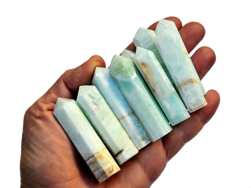 Several blue caribbean calcite crystal points 55mm-65mm on hand with white background