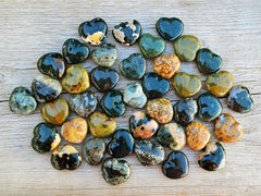 Several ocean jasper crystal hearts 30mm on wood table