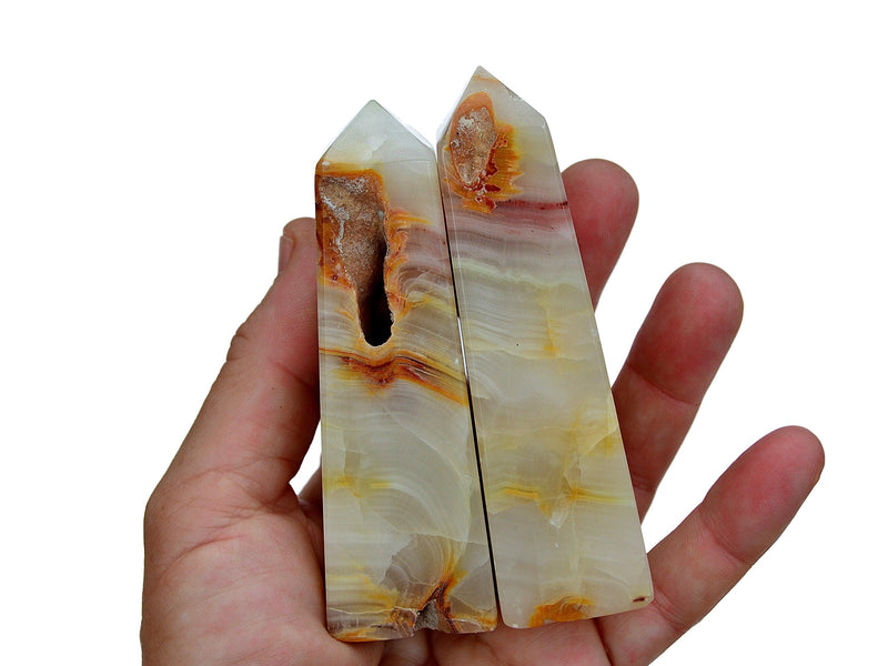 Three pink banded onyx tower crystals 90mm-100mm on hand with white background