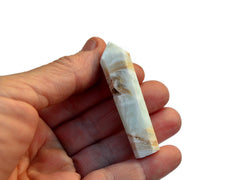 One blue calcite caribbean calcite point crystals 55mm on hand with white background