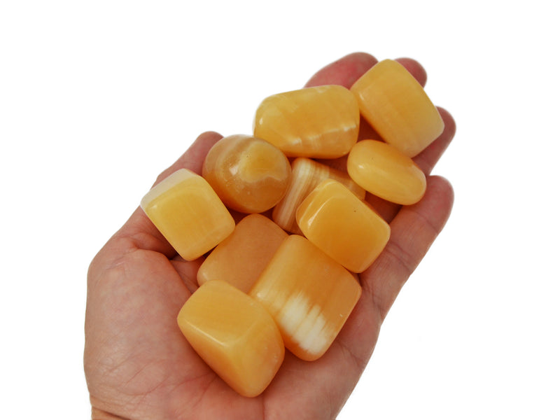 Ten orange calcite mini tumbled stones on hand with white background