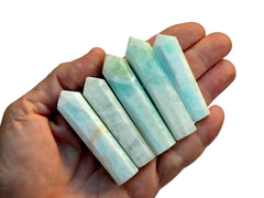 Five blue caribbean calcite crystal points 55mm-65mm on hand with white background