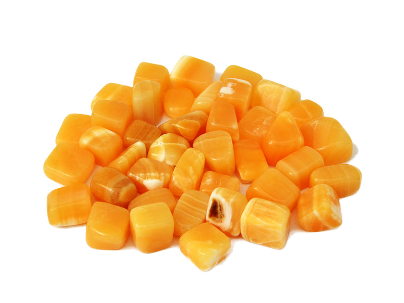 Several orange calcite mini tumbled crystals on white background