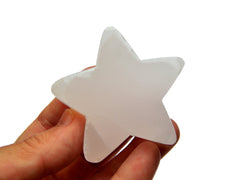 One pink mangano calcite star carved crystal 60mm on hand with white background 