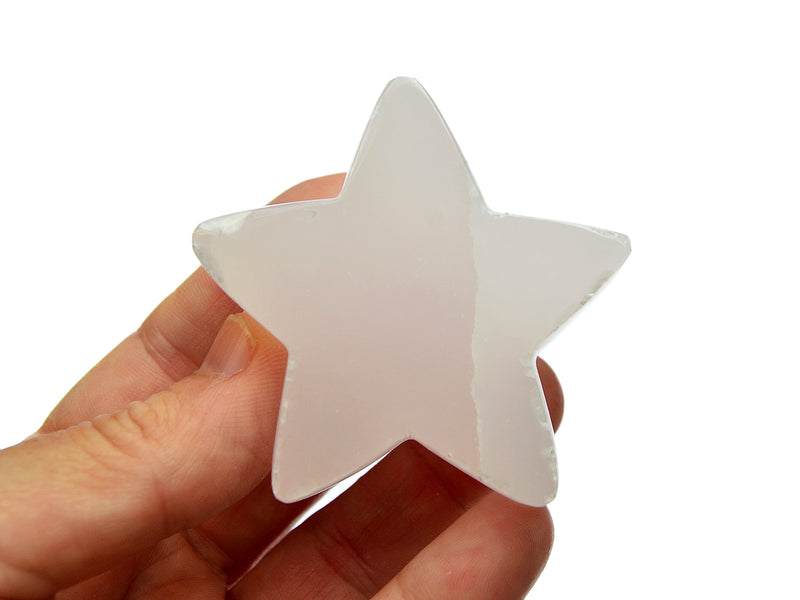 One pink mangano calcite star 60mm on hand with white background 