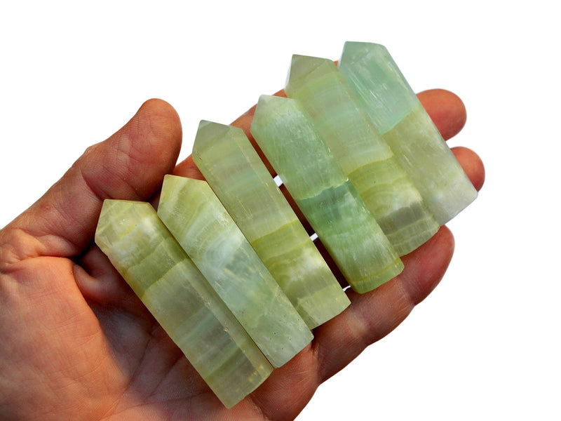 Six pistachio calcite crystal points 50mm-55mm on hand with white background