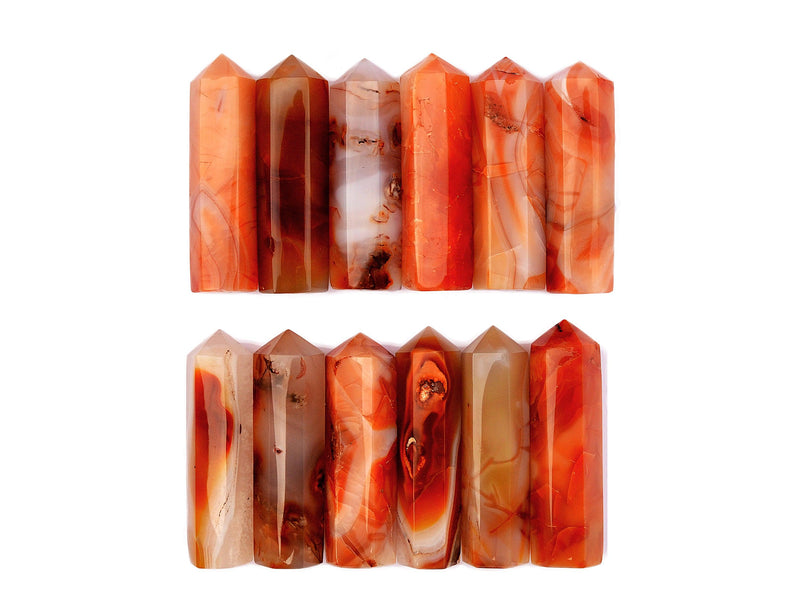 Several natural carnelian obelisk crystals 90mm forming two rows on white background