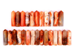Several natural carnelian crystal towers  90mm forming two rows on white background
