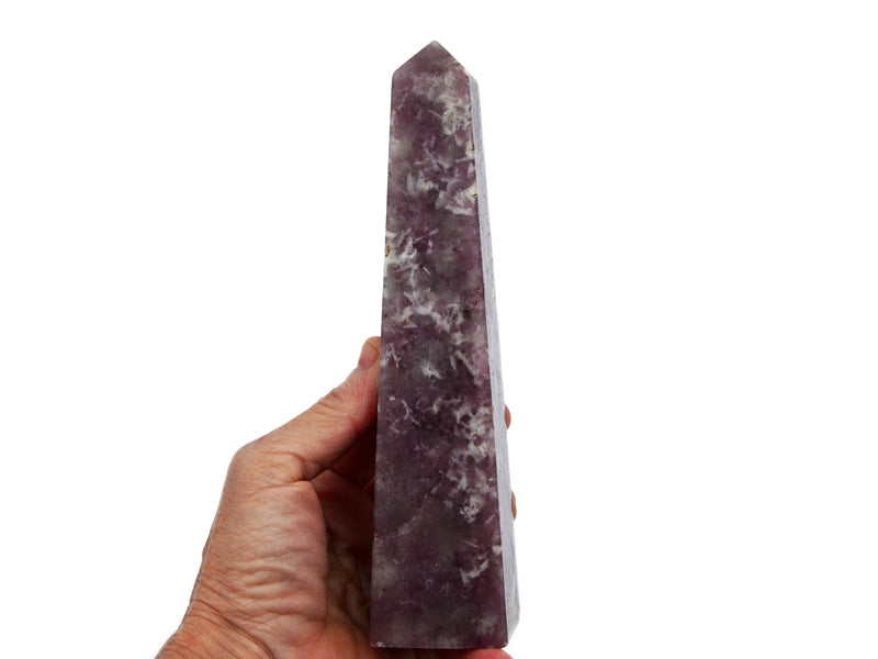 One large lepidolite obelisk stone 150mm on hand with white background