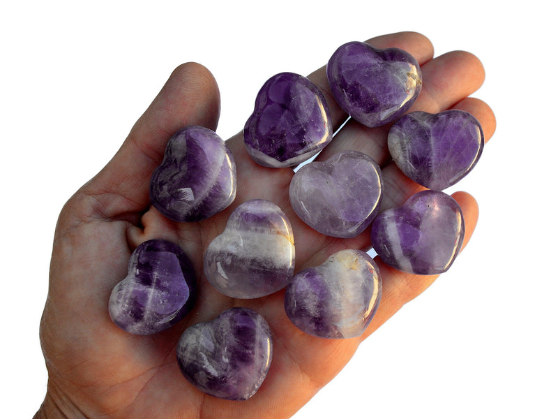 Ten small amethyst heart crystals 30mm on hand with white background