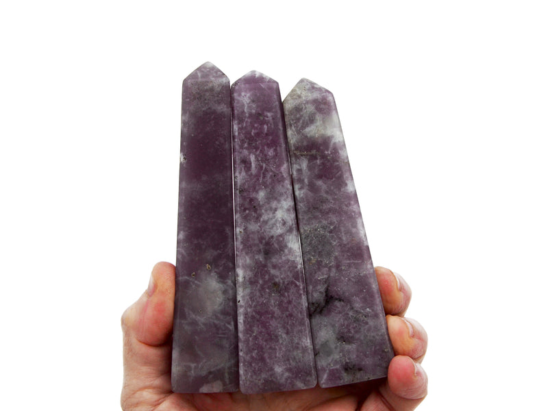 Three lepidolite obelisks stones 100mm on hand with white background