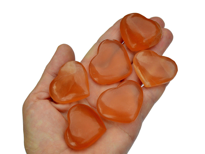 Siz honey calcite hearts 40mm on hand with white background