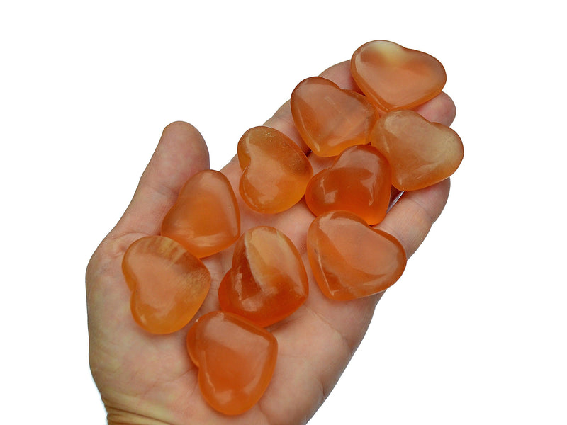 Siz honey calcite hearts 35mm on hand with white background