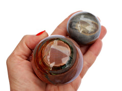 Two desert jasper sphere stones 65mm - 40mm on hand with white background