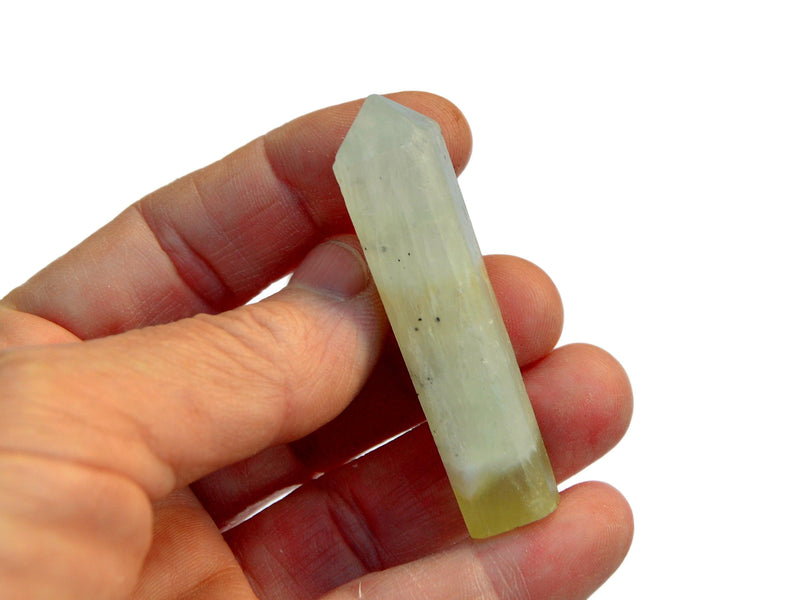 One green pistachio calcite crystal point 50mm on hand with white background 