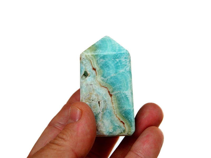 One blue aragonite obelisk 50mm on hand with white background