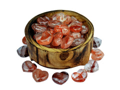 Some fire quartz crystal hearts 30mm inside a bowl with some stones outside around