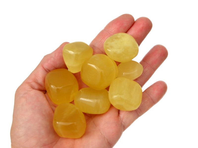 Eight lemon calcite tumbled minerals on hand with white background