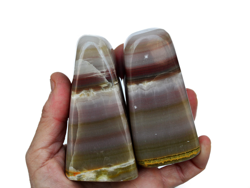 Two pink banded onyx free forms 80mm-90mm on hand with white background