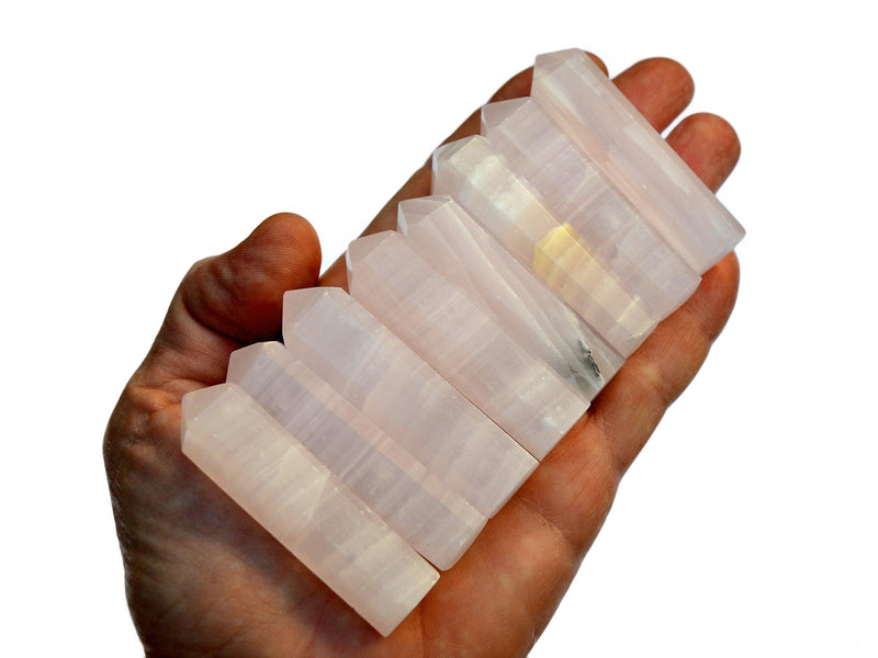 Eight small pink mangano calcite faceted crystal points 55mm-60mm on hand with white background