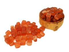 Some honey calcite inside a wood bowl and some crystals outside arround on white background