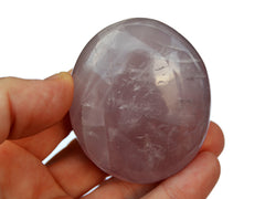 One pink quartz palm stone 55mm on hand with white background