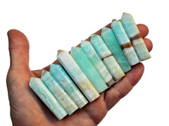 Ten blue caribbean calcite faceted crystal points 45mm-60mm on hand with white background