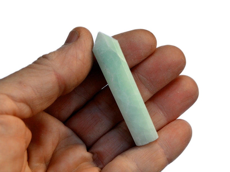 One blue calcite crystal point 55mm on hand with white background