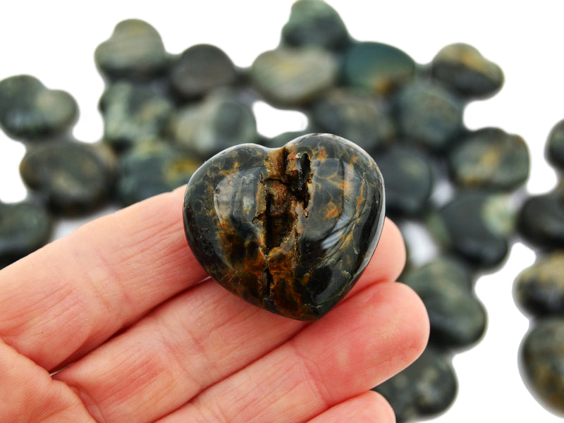 One ocean jasper small heart 35mm on hand with background with some stones on white