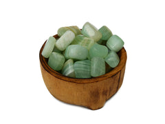 Some pistachio calcite cube tumbled stones nside a wood bowl