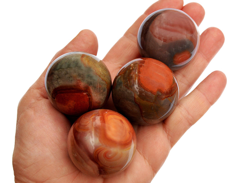 Four multicolor polychrome jasper sphere crystals 45mm on hand  with white background