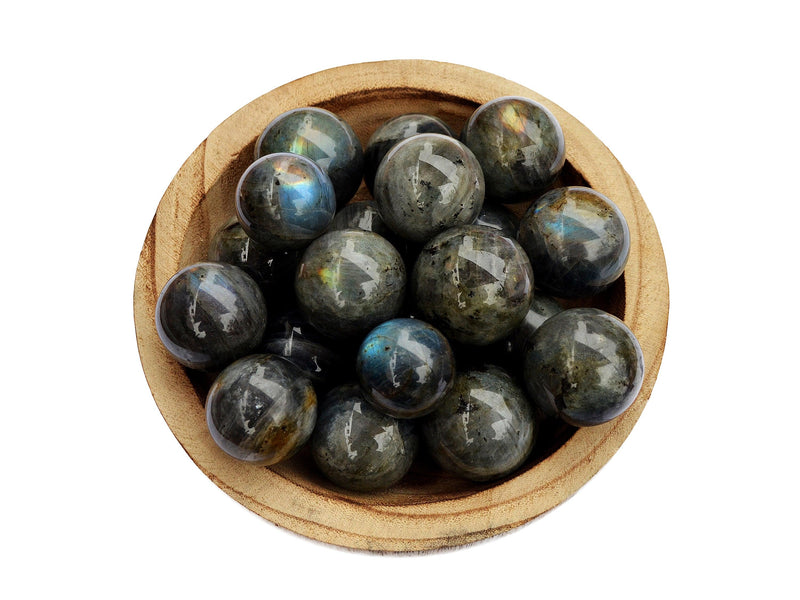 Several labradorite crystal balls 25mm-40mm inside a wood bowl on white background