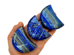 Three lapis lazuli moon carving minerals 65mm on hand with white background